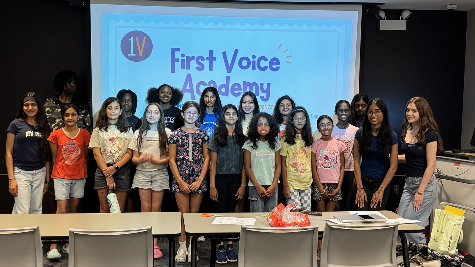 First Voice Academy students and instructors gathered in front of the program screen at the Naperville Public Library.